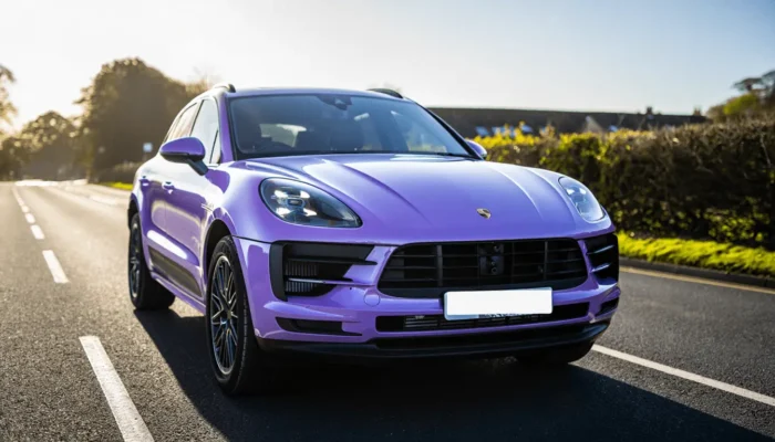 Purple Porsche on the road in sunny conditions