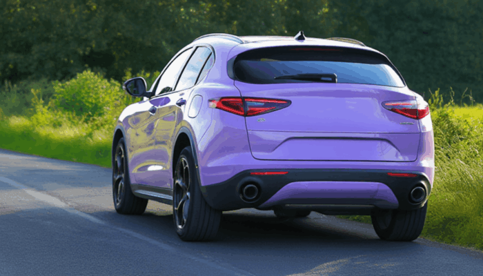 rear of alfa romeo car driving on a uk road in the sunshine