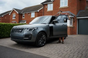 Range Rover parked on the drive, with someone standing by an open passenger door