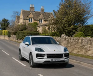 White Porsche driving on the road in the United Kingdom on a sunny day