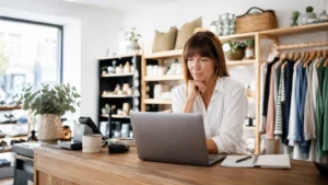 a business owner looking at her laptop working out what business retail insurance covers