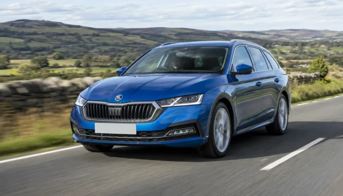 Blue Skoda Octavia estate driving on a country road through green hills